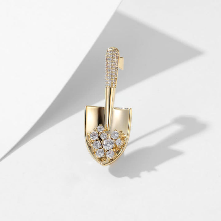 Broche unisex con forma de pala en miniatura chapada