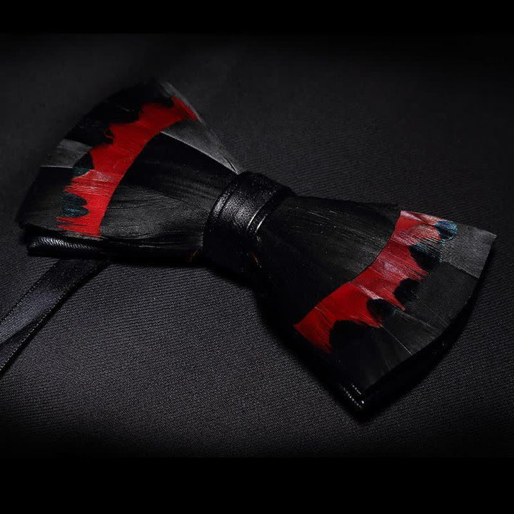 Pajarita infantil con plumas de cisne negras y rojas y broche de solapa