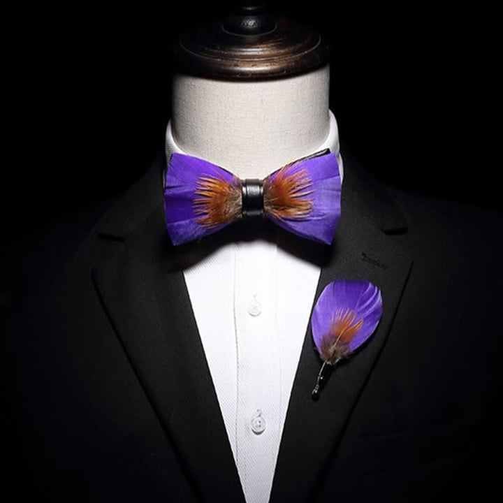 Pajarita con plumas y adornos morados y naranjas con broche de solapa