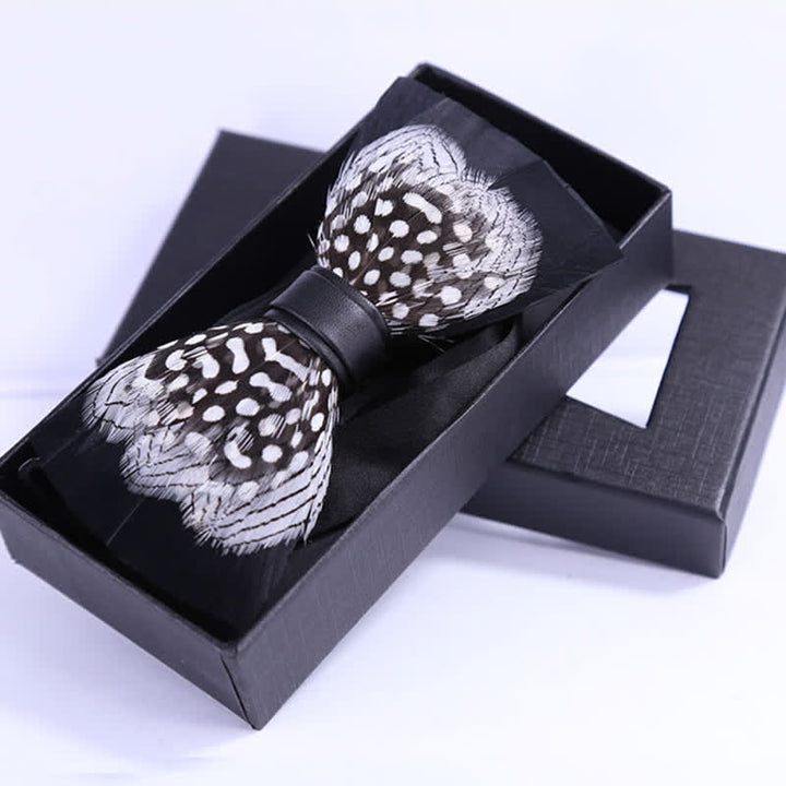 Pajarita de plumas entrelazadas en blanco y negro con prendedor de solapa