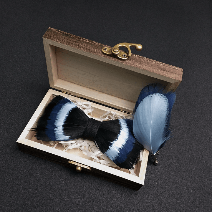 Pajarita con plumas negras y azules y broche de solapa
