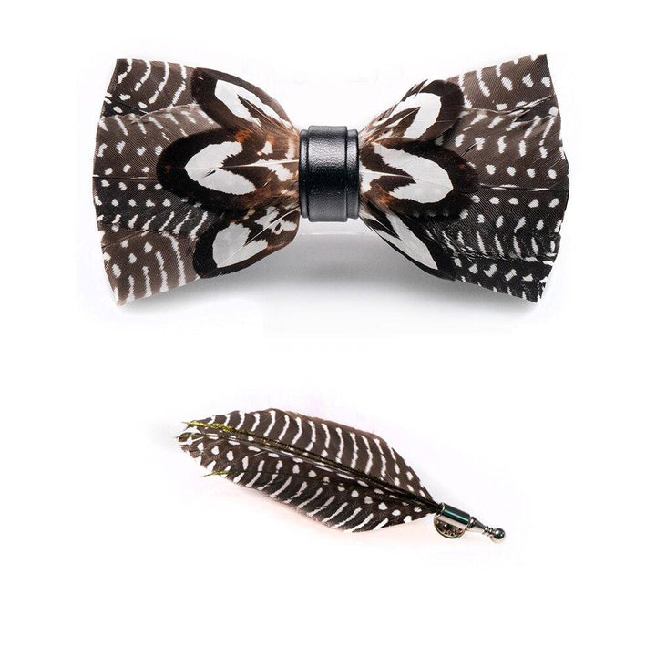 Pajarita de plumas con lunares marrones y blancos y broche de solapa