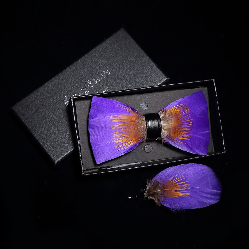 Pajarita con plumas y adornos morados y naranjas con broche de solapa