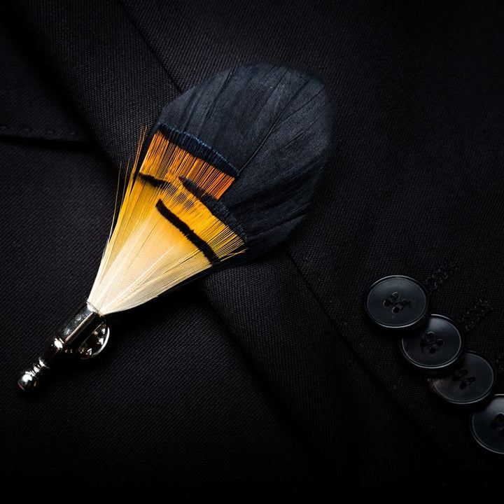 Pajarita con plumas de medianoche en color negro y naranja y broche de solapa