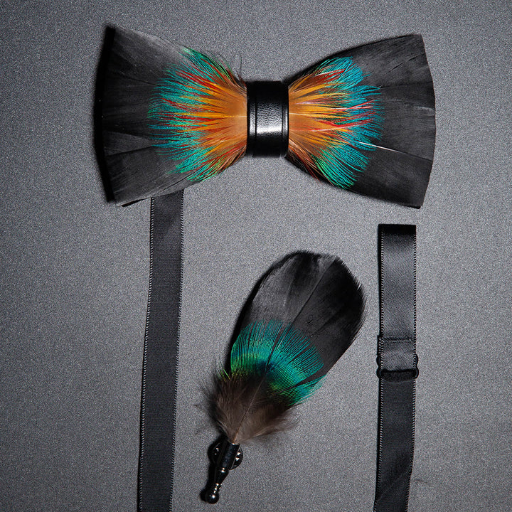 Pajarita de plumas nobles en color negro y naranja con prendedor de solapa