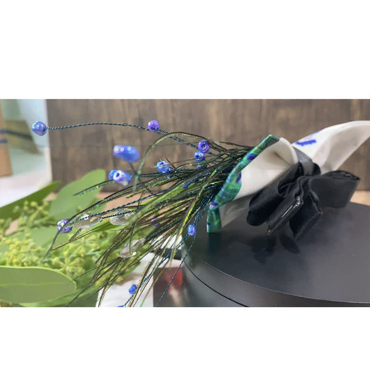 Pajarita con plumas y cuentas de cola de pavo real azul