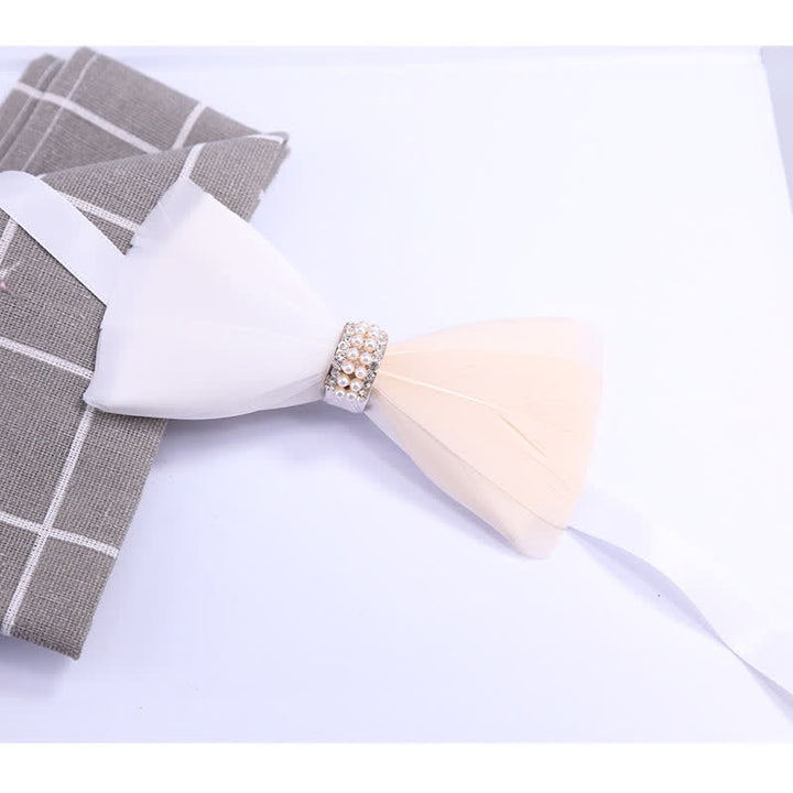 Pajarita con plumas de perla brillante en blanco y rubor y broche de solapa