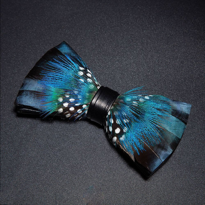 Pajarita con plumas de pavo real azul y negro y broche de solapa