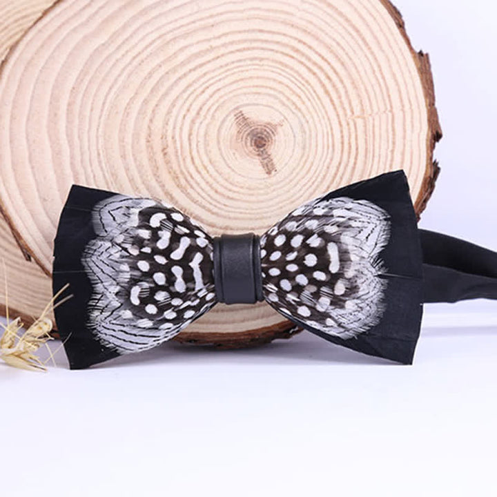 Pajarita de plumas entrelazadas en blanco y negro con prendedor de solapa