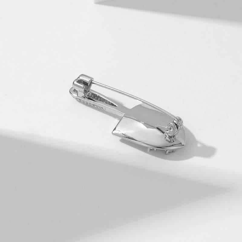 Broche unisex con forma de pala en miniatura chapada