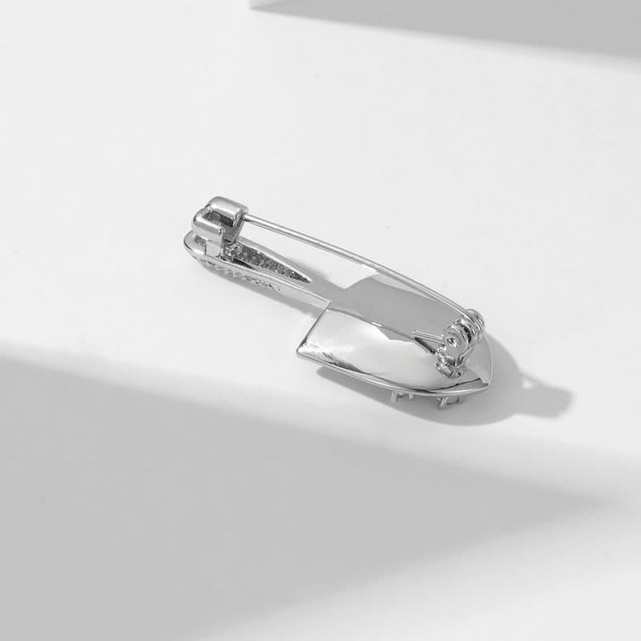Broche unisex con forma de pala en miniatura chapada
