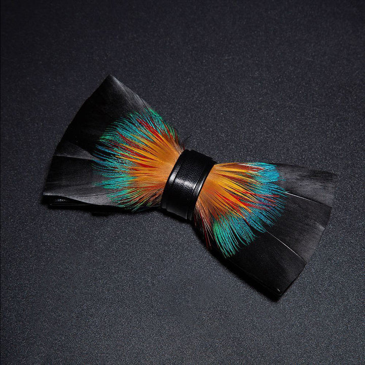 Pajarita de plumas nobles en color negro y naranja con prendedor de solapa