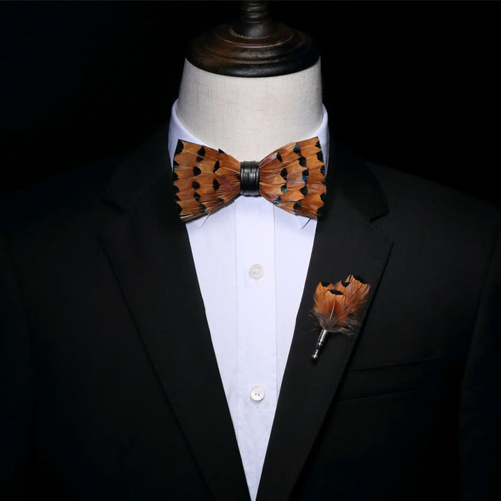 Pajarita con plumas y ribete negro y leonado y broche de solapa
